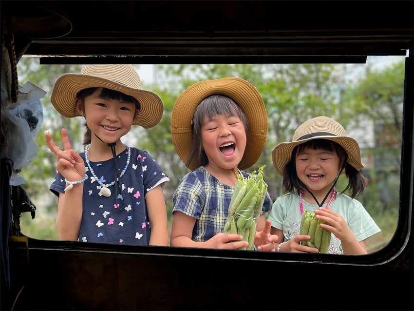 収穫した野菜を手にする子どもたち — JoyFarm